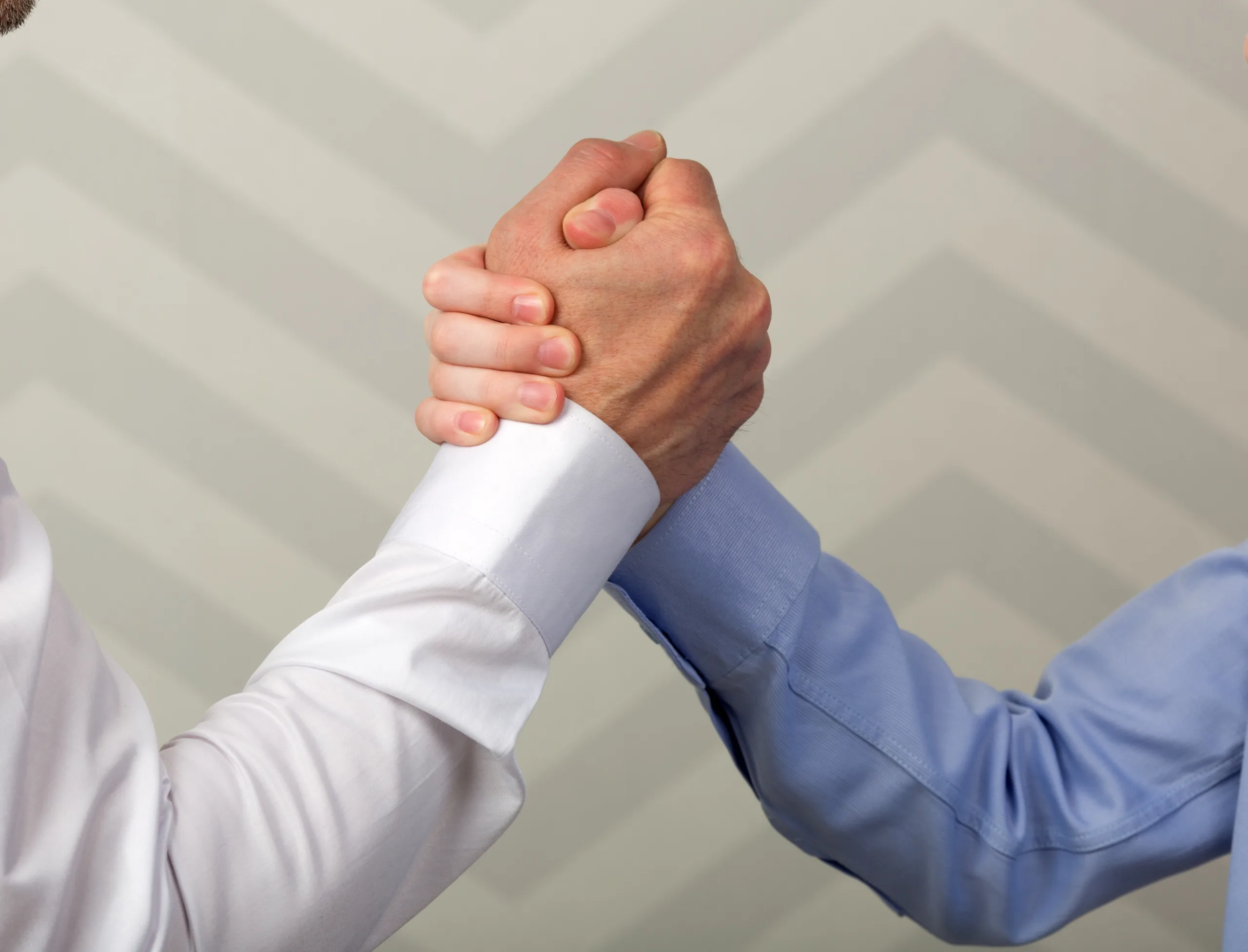 Father and son with hands in strong handshake or during arm wrestling competition