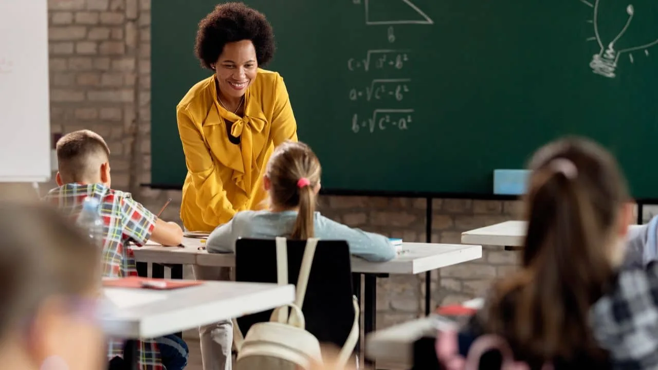 Professora orienta alunos durante aula. Foto: Freepik