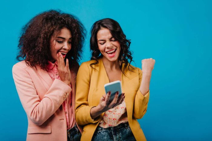 Excited latin woman making selfie with friend. Trendy african girl posing in studio.