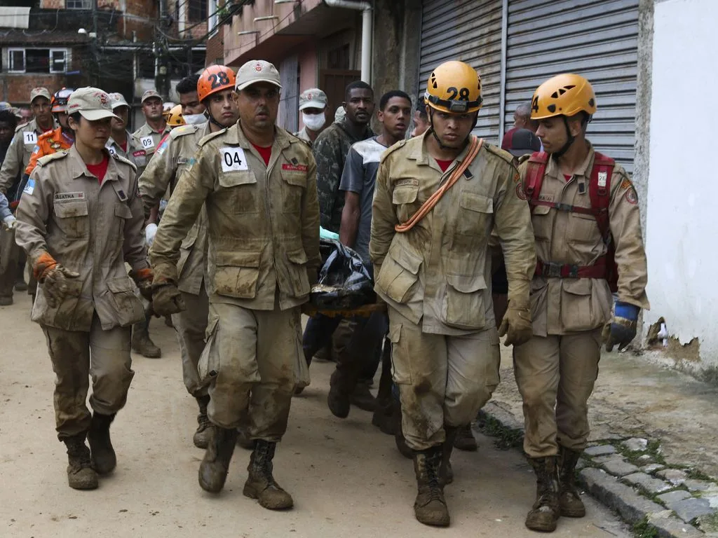 Bombeiros, moradores e voluntários trabalham no local do deslizamento no Morro da Oficina, após a chuva que castigou Petrópolis, na região serrana fluminense