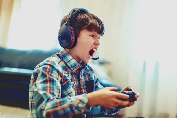 Crazy dependent kid shouting while playing mass multiplayer video game online at home