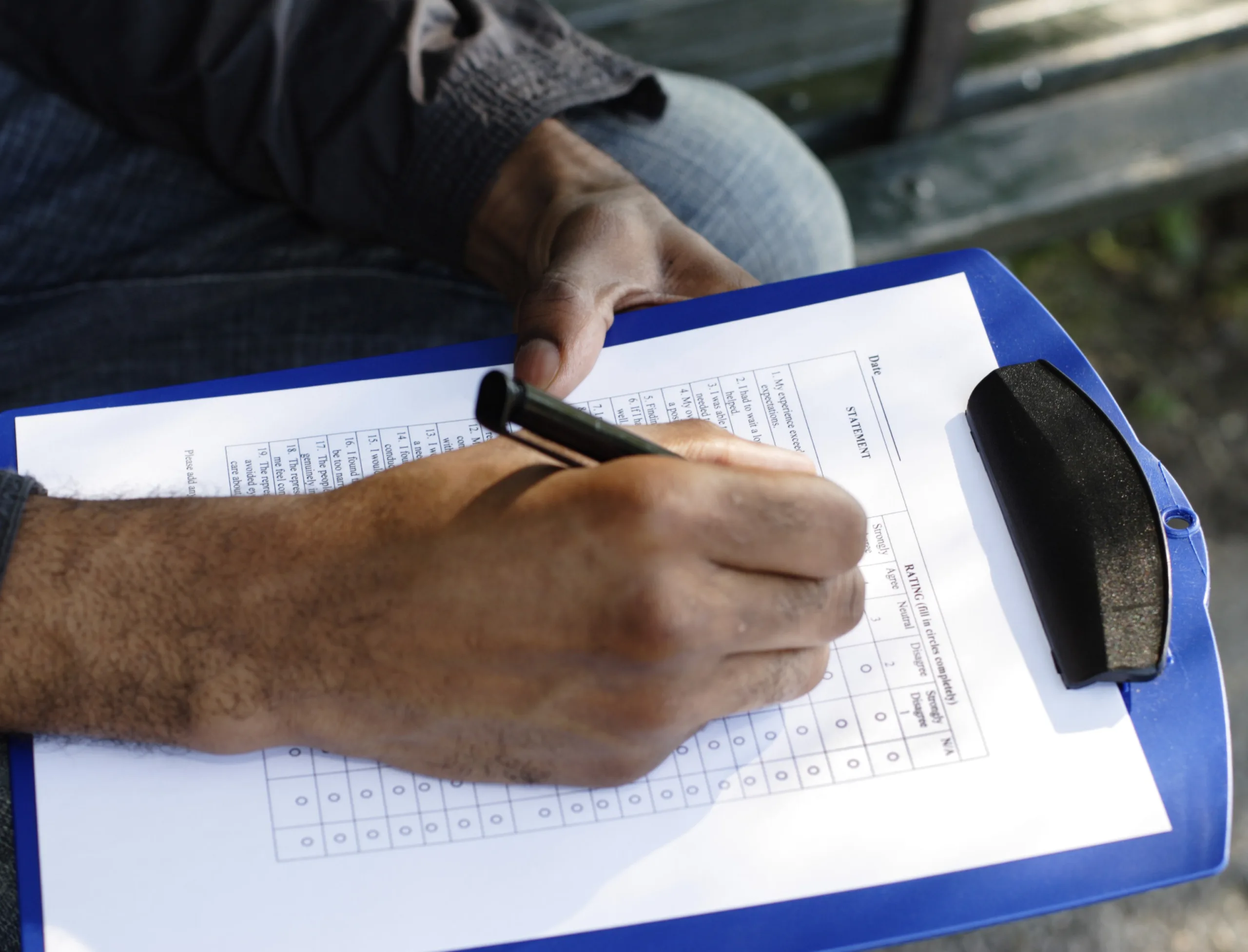 Close-up of a man’s hand filling out survey form. [url=/my_lightbox_contents.php?lightboxID=4496516]Click here for more[/url] with this model.