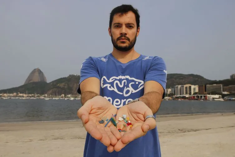 Rio de Janeiro – O biólogo Jonas Leite, doutor em oceanografia, presidente do Instituto Meros do Brasil, mostra microplástico vindo do mar coletado na areia da praia de Botafogo. (Fernando Frazão/Agência Brasil)