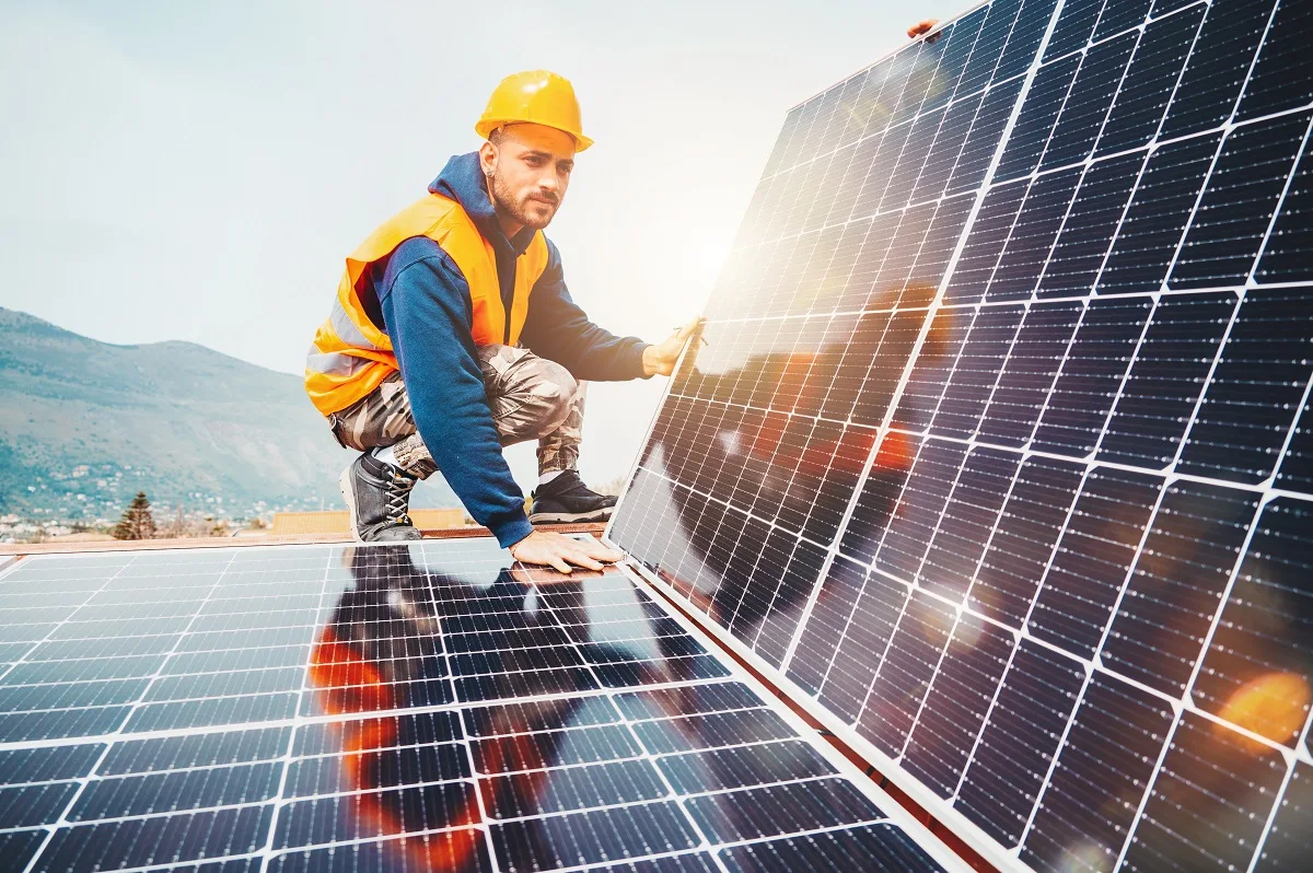 Workers assemble system with solar panel for electricity