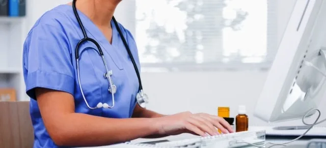 Female surgeon using computer at clinic