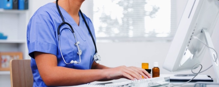 Female surgeon using computer at clinic