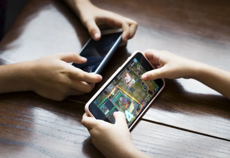 Little boy playing a mobile game against his sister