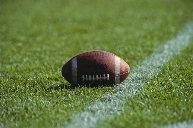 ca. 1990 — Football on the Grass at the Yardline — Image by © Duomo/CORBIS