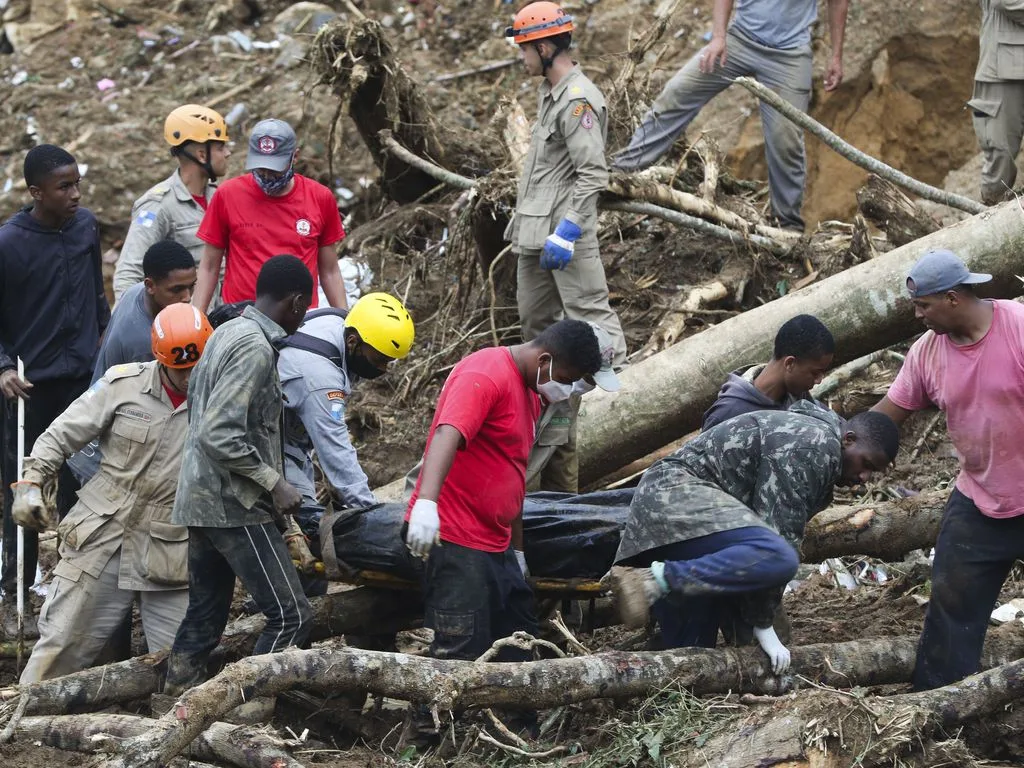 Bombeiros, moradores e voluntários trabalham no local do deslizamento no Morro da Oficina, após a chuva que castigou Petrópolis, na região serrana fluminense