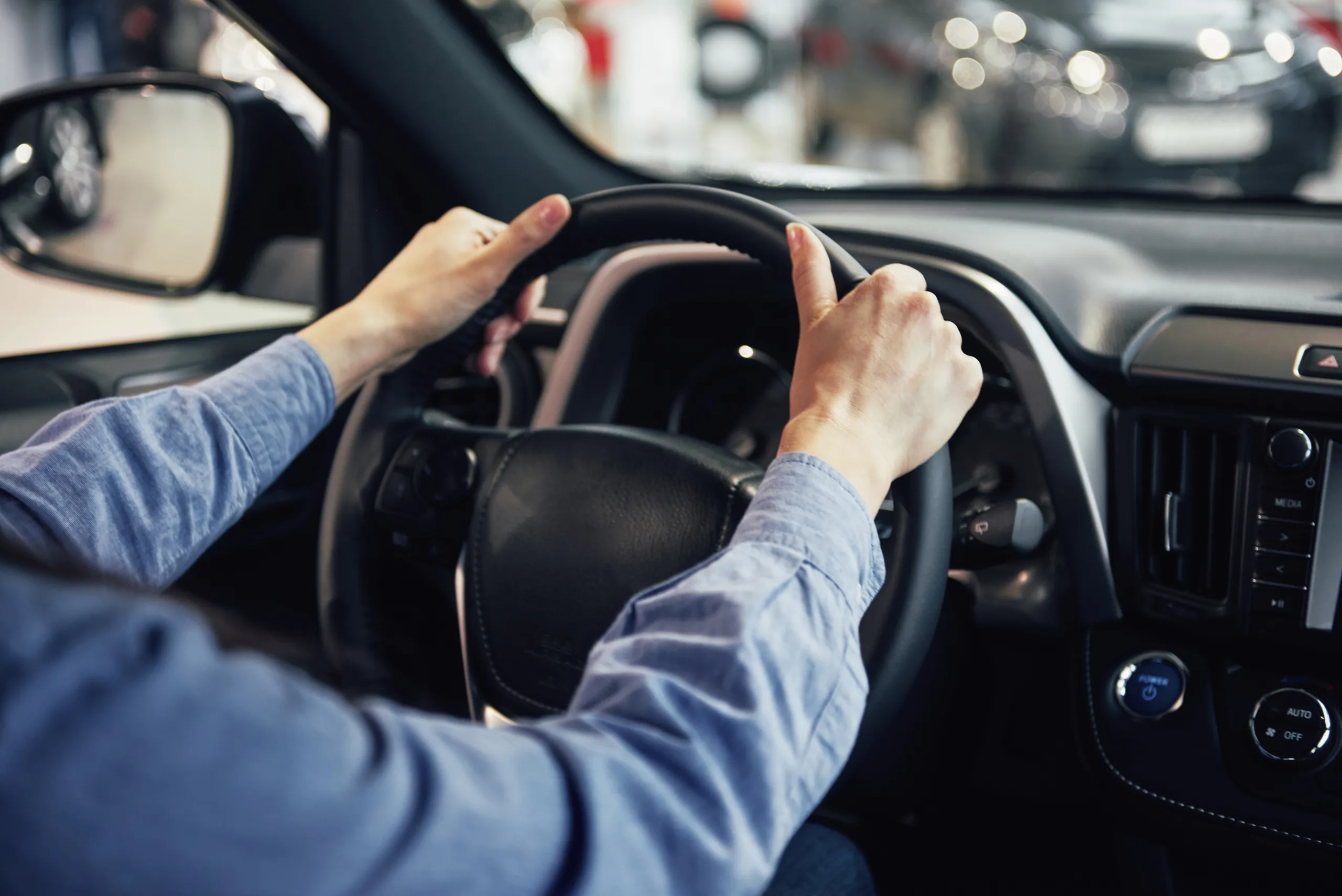 auto business, car sale, consumerism and people concept – happy woman taking car key from dealer in auto show or salon.