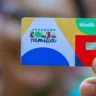 Mulher segura o cartão do Bolsa Família