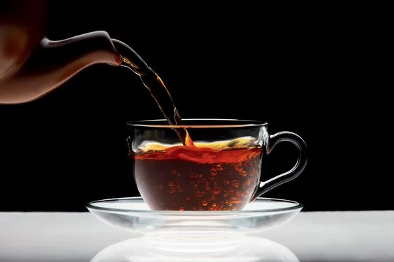 Pouring black tea into transparent cup isolated on black background Credito: Sergio Kumer/Getty Images