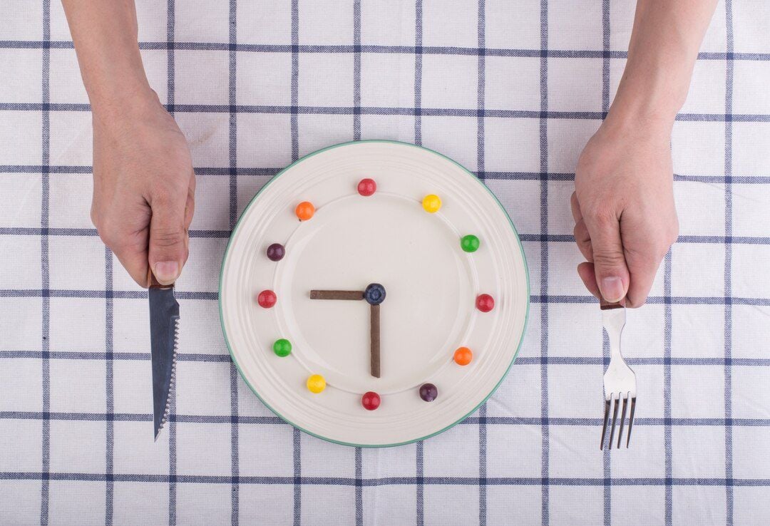 Imagem mostra prato com pequenos chocolates coloridos, ilustrando um relógio.