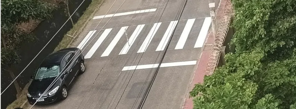 Faixa que leva pedestres para dentro de valão é pintada em avenida de Vila Velha