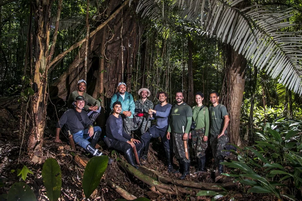 Equipe de pesquisa e fotógrafos colaborando na documentação da vida selvagem, exemplificando a união de ciência e arte.Finalidade da Imagem: A imagem demonstra a colaboração entre pesquisadores e fotógrafos, destacando a importância de trabalhos conjuntos na documentação e na preservação da natureza.