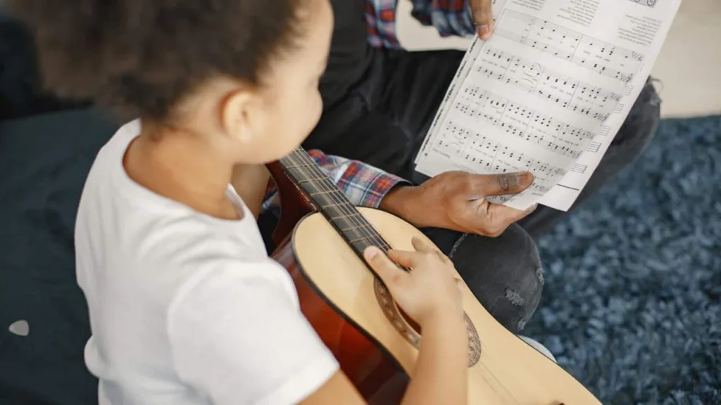 Criança aprende a ler partitura musical. Foto: Freepik