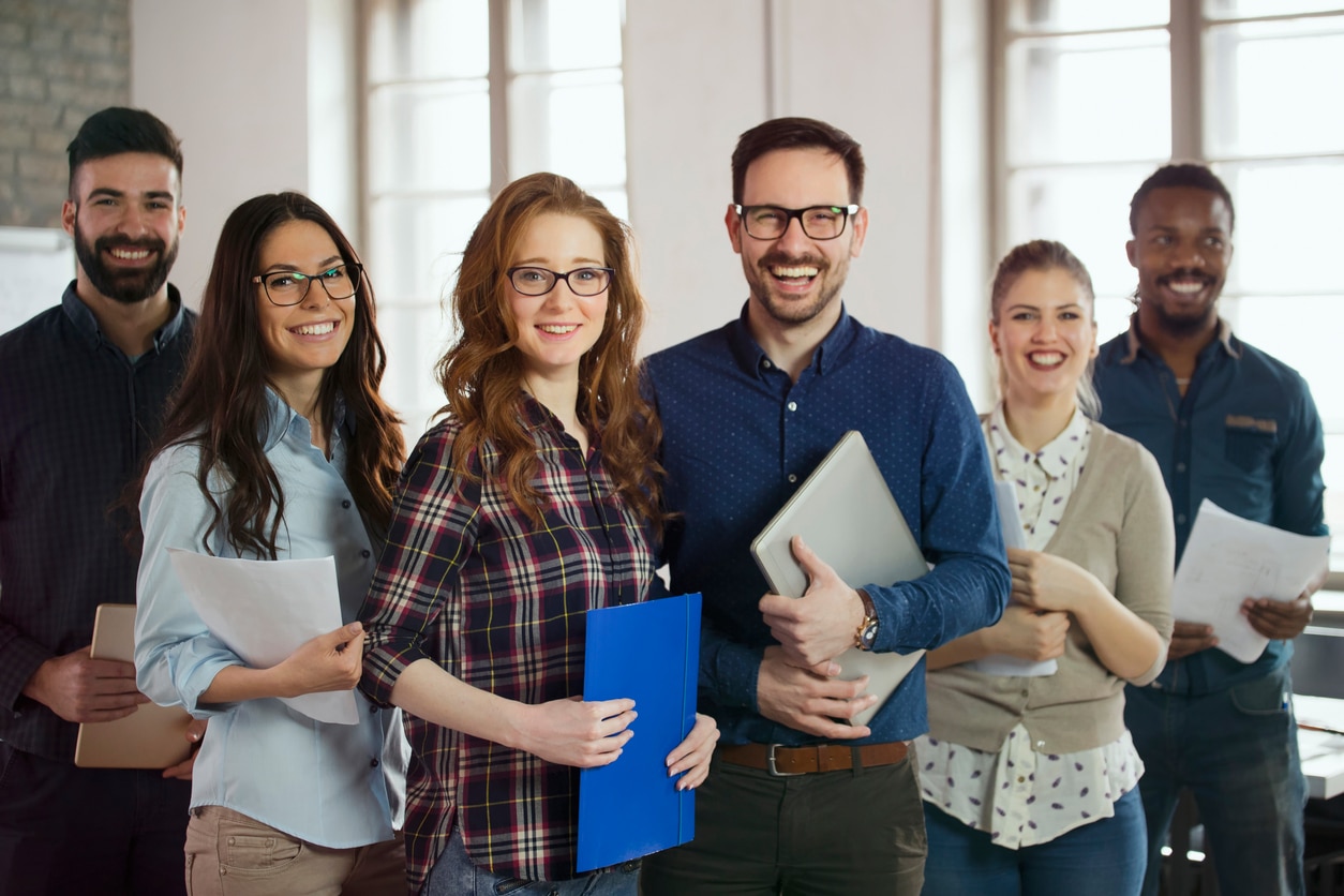 Group picture of young successful team of designers posing in office