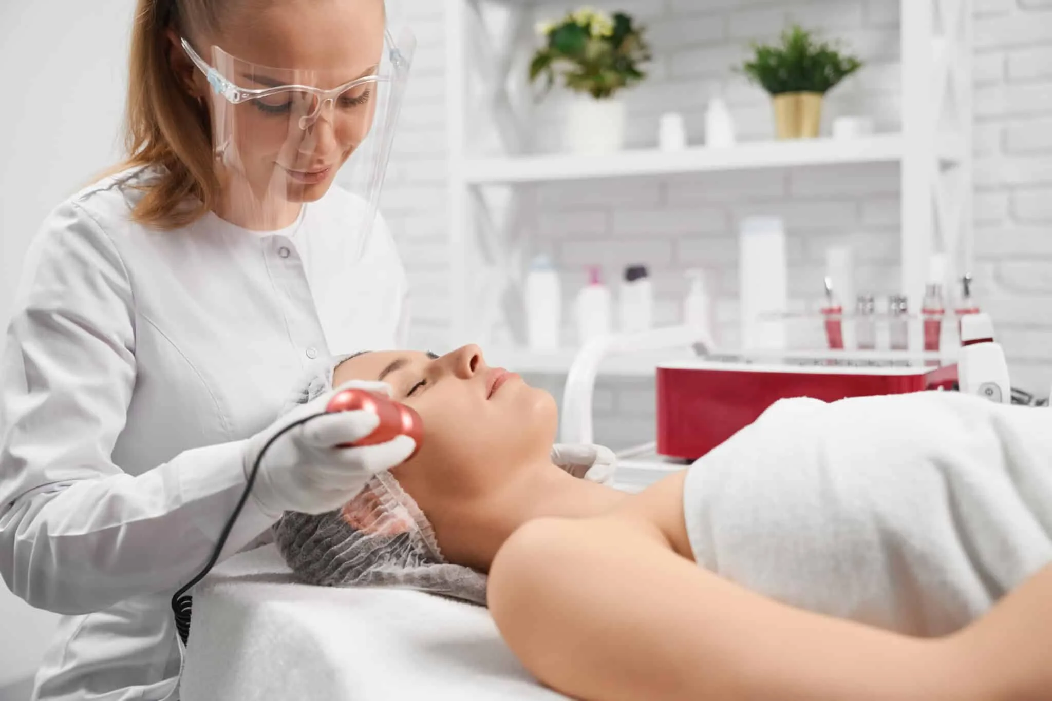 Side view of woman lying on sofa on procedure cleaning face in professional salon. Concept of special beauty procedure for improvements skin face and body.