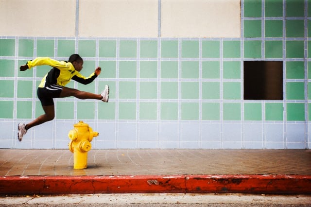 Woman leaping over a fire hydrant — Image by © Mango Productions/Corbis