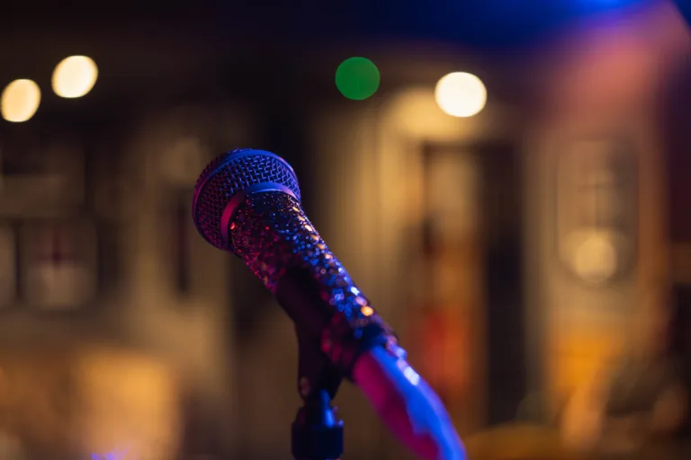 A closeup shot of a microphone on a blurred background with bokeh lights