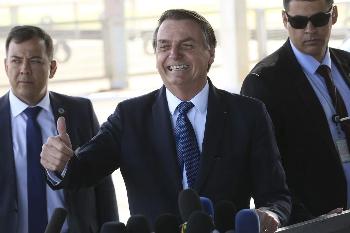 O presidente Jair Bolsonaro, cumprimenta populares no Palácio da Alvorada