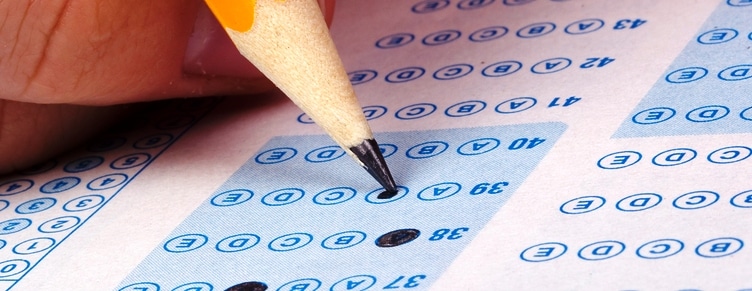 Student filling out answers to a test with a pencil.