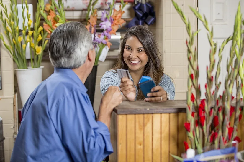 Smiling, handsome, Hispanic small business flower shop owner standing in his outdoor shop