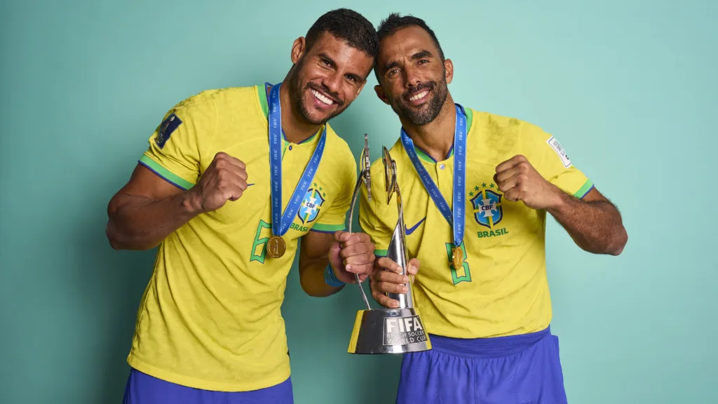 Breno e Bruno Xavier com a camisa da seleção brasileira segurando as medalhas, lado a lado