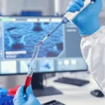 Pesquisador utilizando tubo de teste com sangue para pesquisas, em laboratório