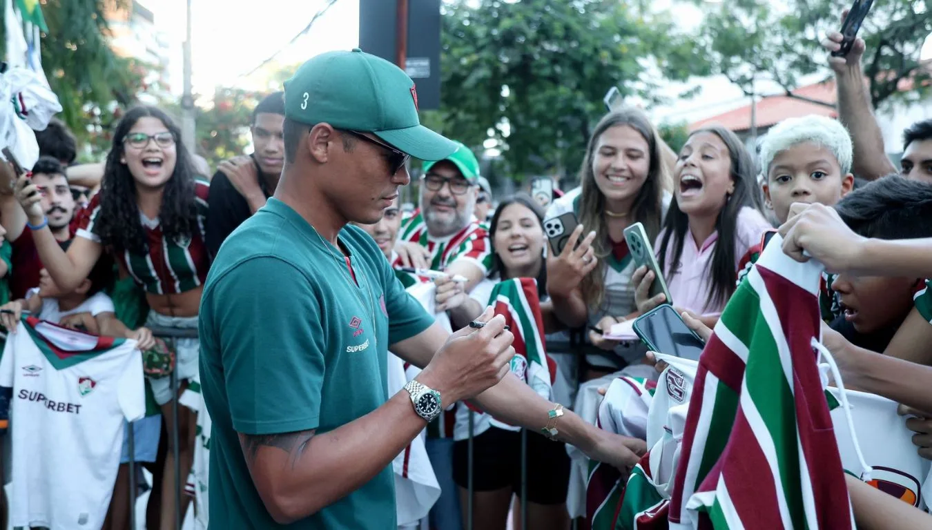 Thiago Silva, com uniforme verde e boné verde, assina autógrafo para torcedor do Fluminense em Vitória