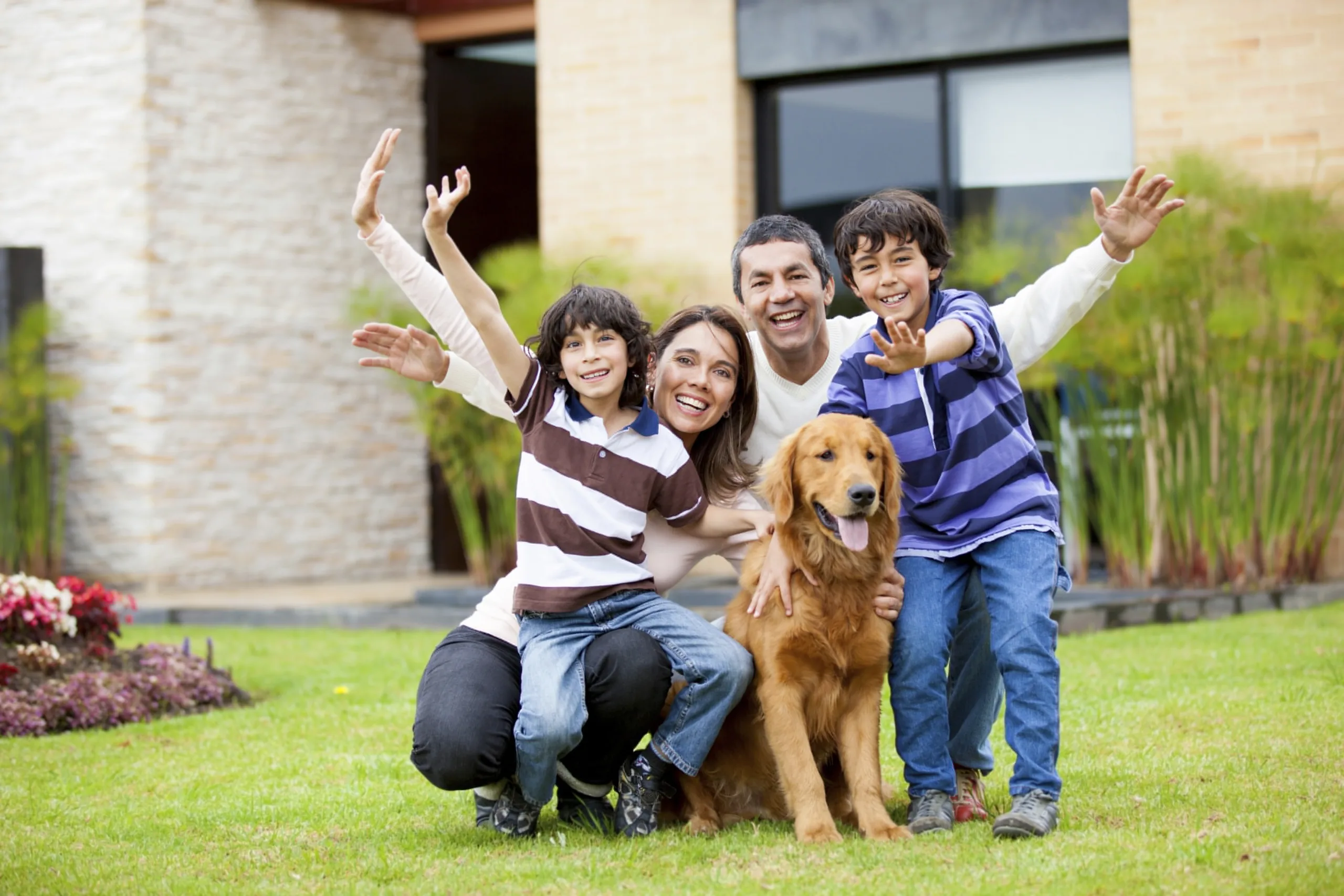 Happy family with a dog outside their house