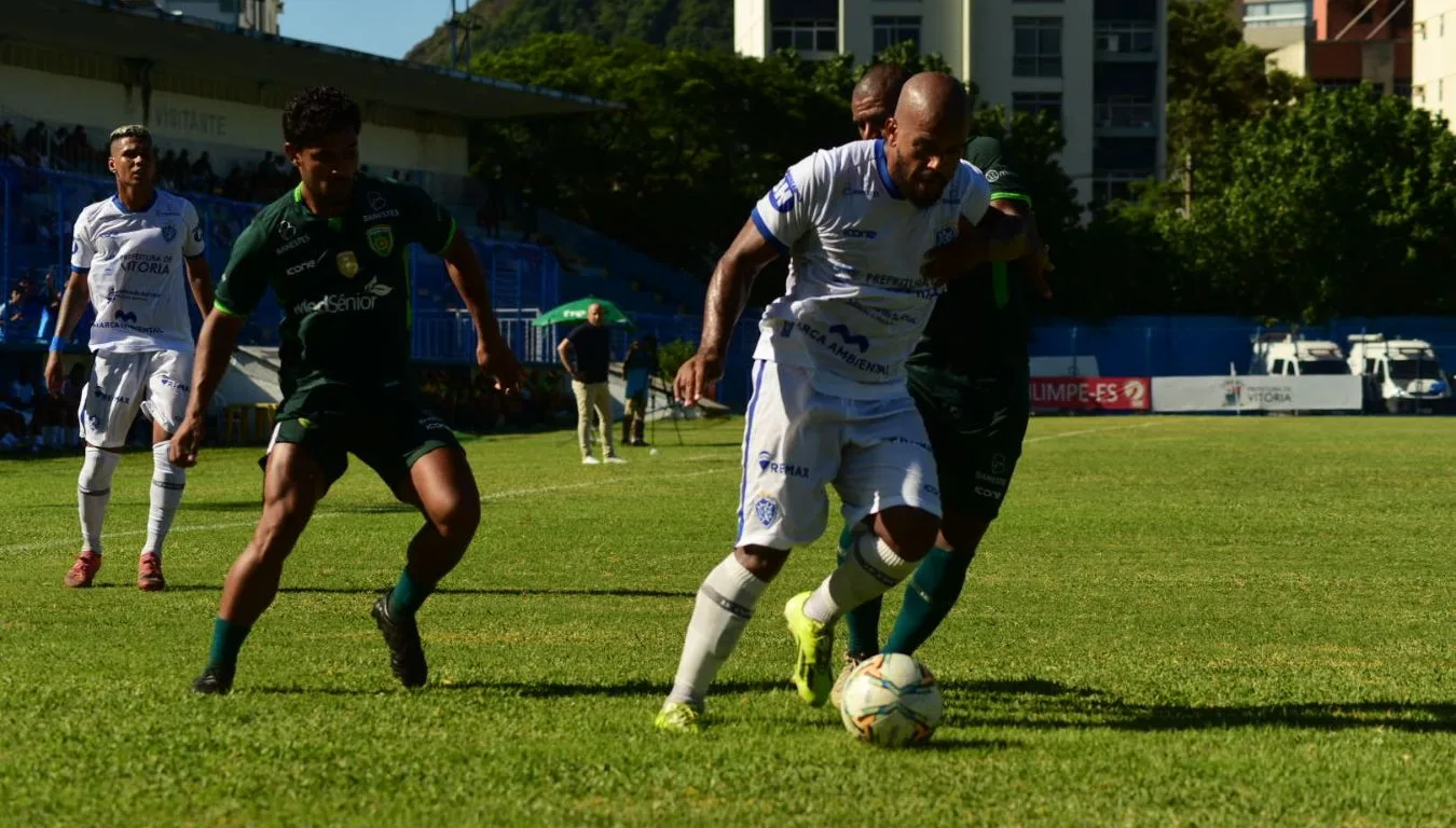 Jogador do Vitória, de uniforme branco, protege a bola