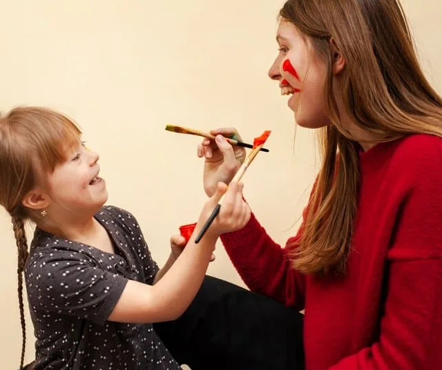 Criança e adulta brincando com pincel e tinta