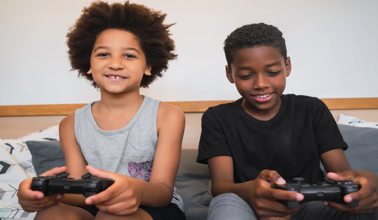 Portrait of two Afro American brothers playing video games at home. Lifestyle and technology concept.