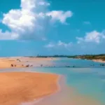 Imagem mostra praia de Urussuquara em dia ensolarado.