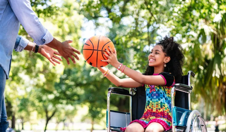 Garota com cadeira de rodas joga basquete