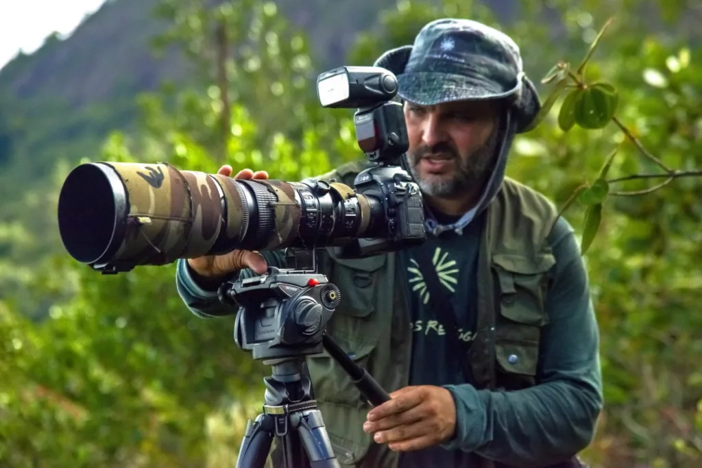 Leonardo Merçon ajustando sua câmera enquanto realiza fotografias externas