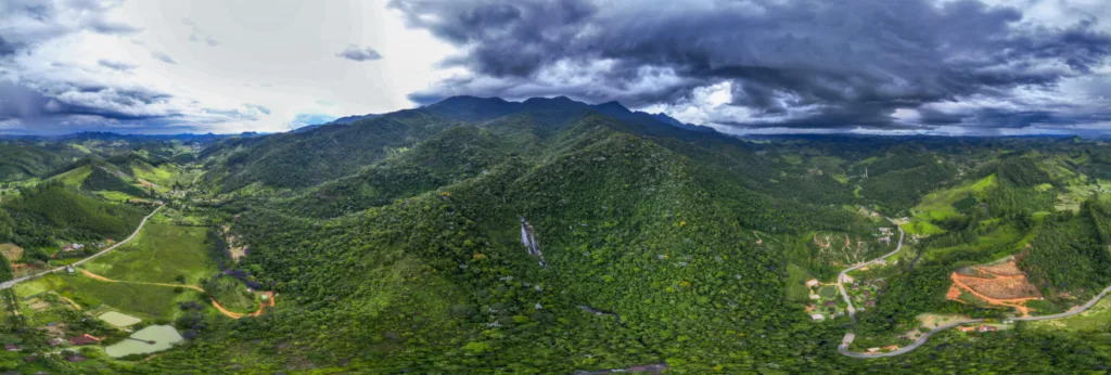 Nascente do Rio Itapemirim com águas cristalinas entre pedras e vegetação no Parque Nacional do Caparaó