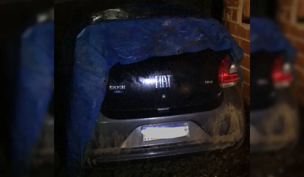 Carro roubado foi encontrado abandonado em um terreno baldio e coberto por uma lona. Foto: Reprodução/ TV Vitória