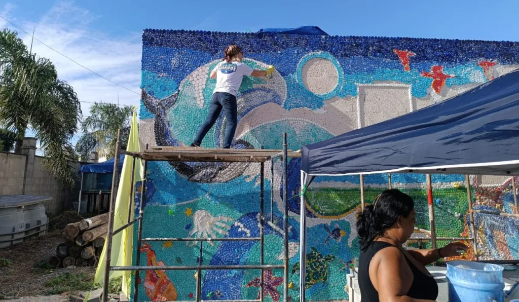 Eco Mural foi feito com 30 mil tampinhas plásticas recolhidas por voluntários. Foto: Marelli Soares/ Instituto Goiamum Eco Mural foi feito com 30 mil tampinhas plásticas recolhidas por voluntários. Foto: Marelli Soares/ Instituto Goiamum