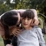Mãe cuida de sua filha com deficiência