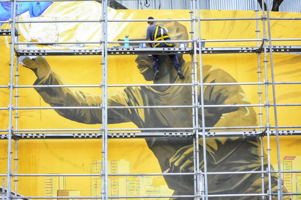 Painel gigante pintado por artistas retrata cultura capixaba na Alça de saída da terceira ponte