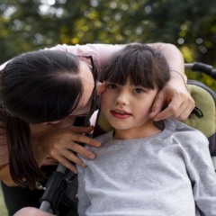 Mãe com criança em cadeira de rodas - crédito: Freepik