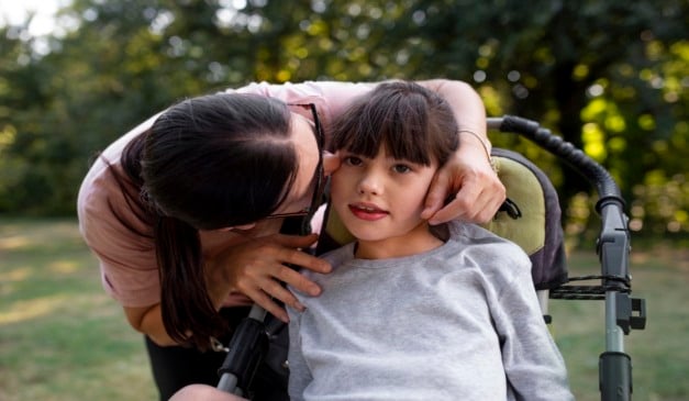 Mãe com criança em cadeira de rodas - crédito: Freepik