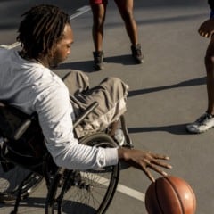 Homem negro joga basquete em cadeira de rodas