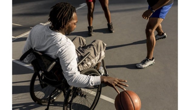 Homem negro joga basquete em cadeira de rodas