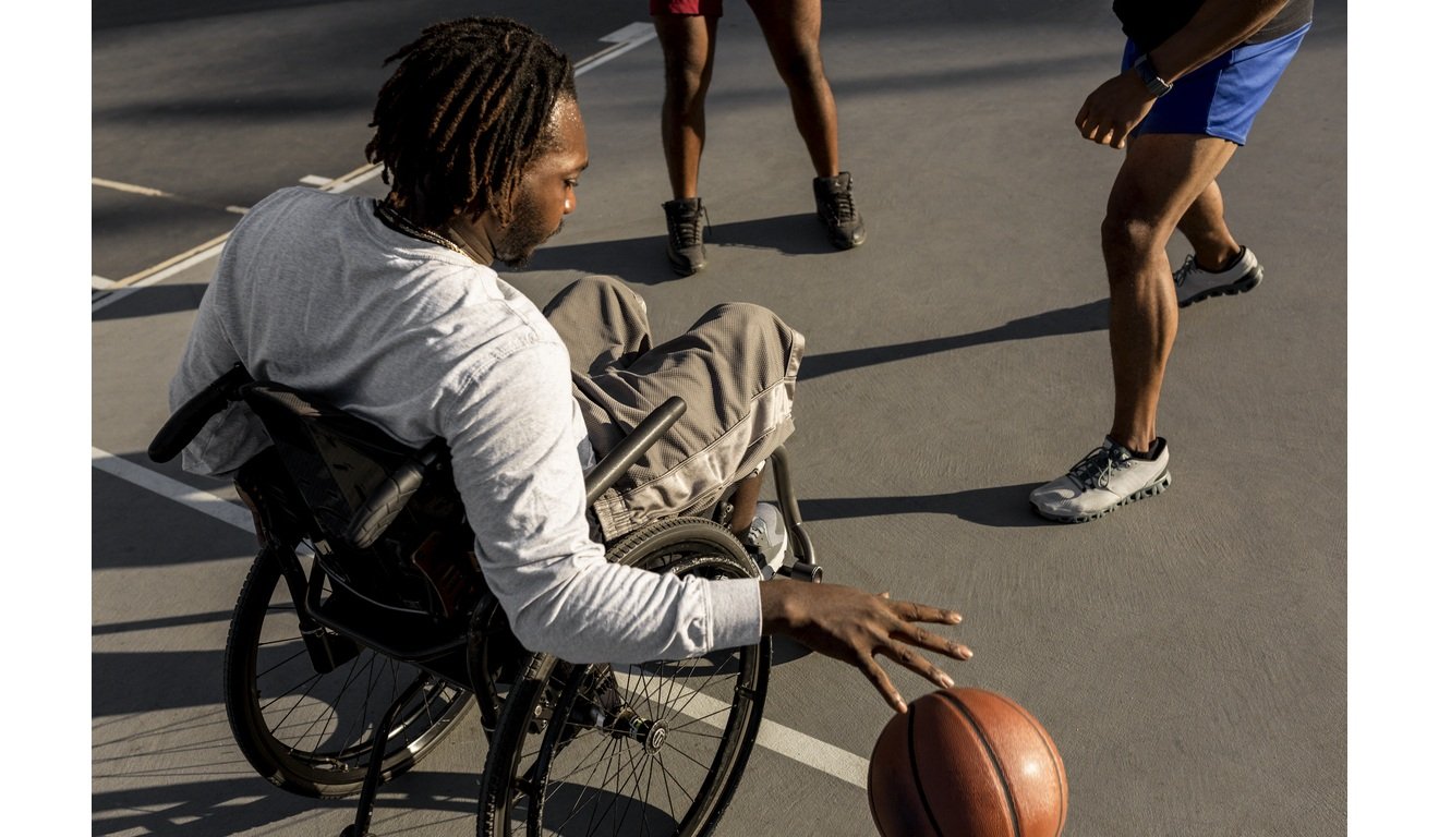 Homem negro joga basquete em cadeira de rodas