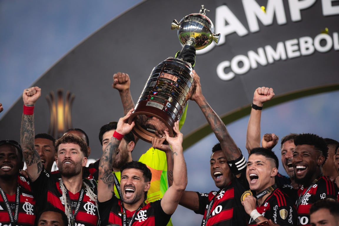 PER - LIBERTADORES/PALMEIRAS X FLAMENGO/FINAL - ESPORTES De Arrascaeta, do Flamengo, ergue o troféu da Copa Libertadores 2025 ao lado dos companheiros após a vitória por 1 a 0 diante do Palmeiras na final, realizada no Estádio Monumental de Lima, no Peru, neste sábado, 29. O Flamengo sagrou-se tetracampeão do torneio. Foto: MARCO GALVãO/ZIMEL PRESS/ESTADÃO CONTEÚDO ZIM20251129007 - 29/11/2025 - 21:47 PER - LIBERTADORES/PALMEIRAS X FLAMENGO/FINAL - ESPORTES De Arrascaeta, do Flamengo, ergue o troféu da Copa Libertadores 2025 ao lado dos companheiros após a vitória por 1 a 0 diante do Palmeiras na final, realizada no Estádio Monumental de Lima, no Peru, neste sábado, 29. O Flamengo sagrou-se tetracampeão do torneio. Foto: MARCO GALVãO/ZIMEL PRESS/ESTADÃO CONTEÚDO ZIM20251129007 - 29/11/2025 - 21:47