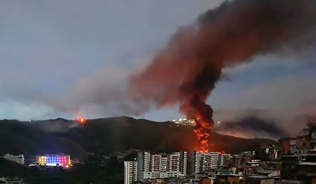 Fumaça e fogo são vistos na região do complexo militar Fuerte Tiuna, em Caracas, após ataque americano Foto: STR Fumaça e fogo são vistos na região do complexo militar Fuerte Tiuna, em Caracas, após ataque americano Foto: STR
