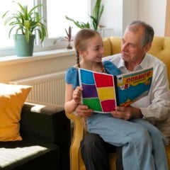 Idoso e criança leem juntos